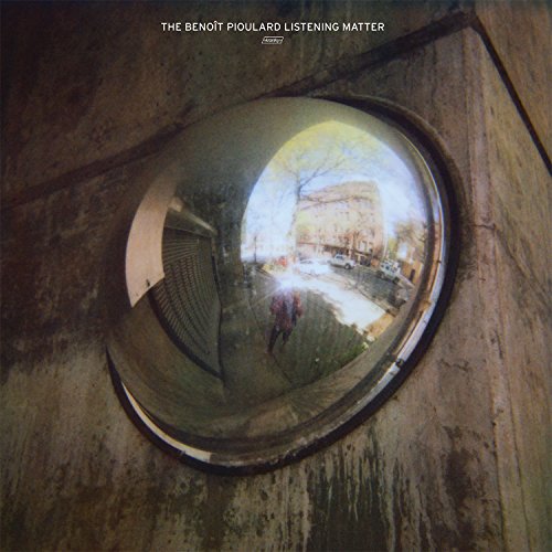 "Album cover with a round mirror reflecting a city street scene."