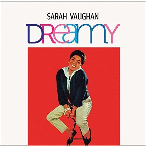 "Singer Sarah Vaughan on a red background, smiling, leaning on a stool."