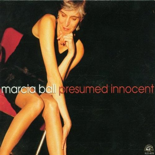 "Album cover featuring a woman in a black dress sitting on a red chair."