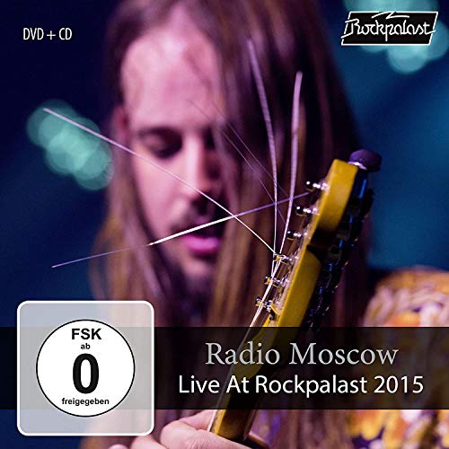 Man with long hair holding a guitar headstock, with "Rockpalast" logo.