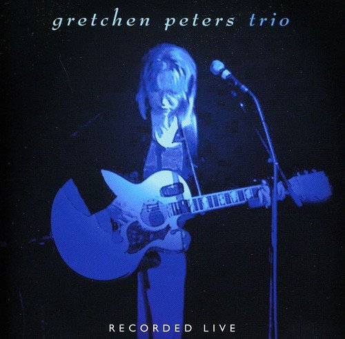 Album cover featuring a woman playing an electric guitar on a dark stage.