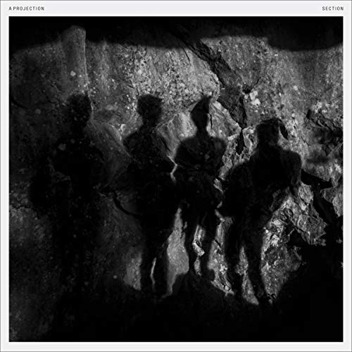 Black and white album cover with silhouettes of three people against a rocky background.
