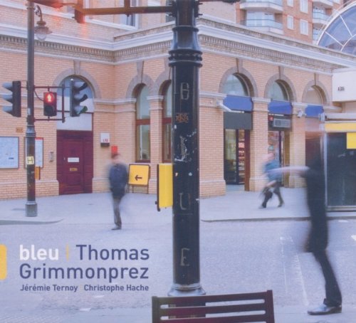 The image shows a city street scene with a CD cover overlay. "CD cover with city street scene, people walking, and traffic lights."