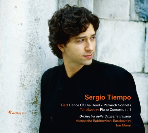 A young man in a black shirt stands against a grey stone wall, CD cover.