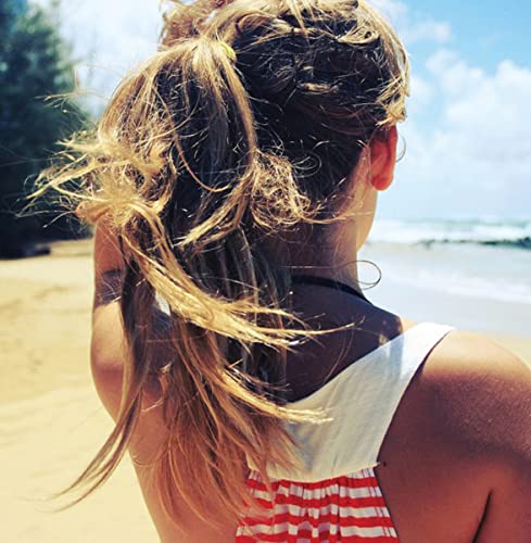 Woman with blonde hair in a ponytail, facing the ocean.