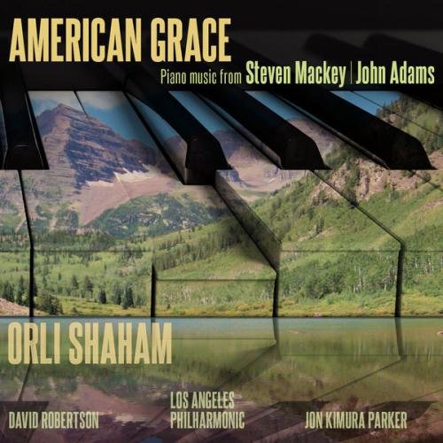 "CD cover with piano keys and a serene mountain landscape reflection."