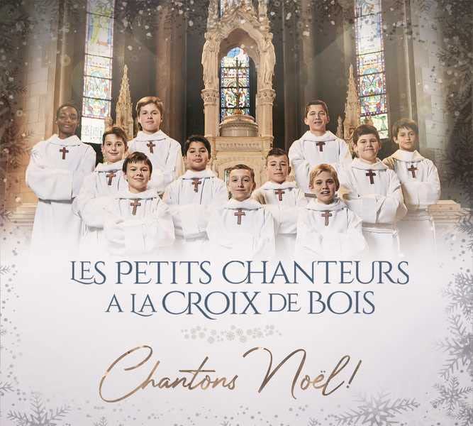 Choir of boys in white robes standing in a church interior.