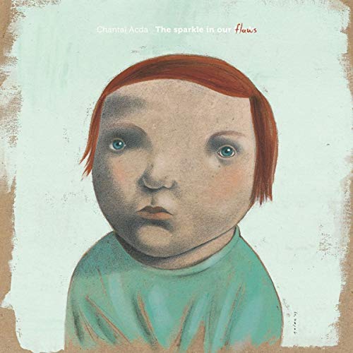 "Album cover featuring a child with red hair and a blue shirt."