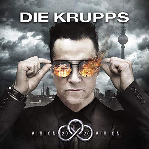 Man in black suit adjusts burning sunglasses, Berlin cityscape behind him.