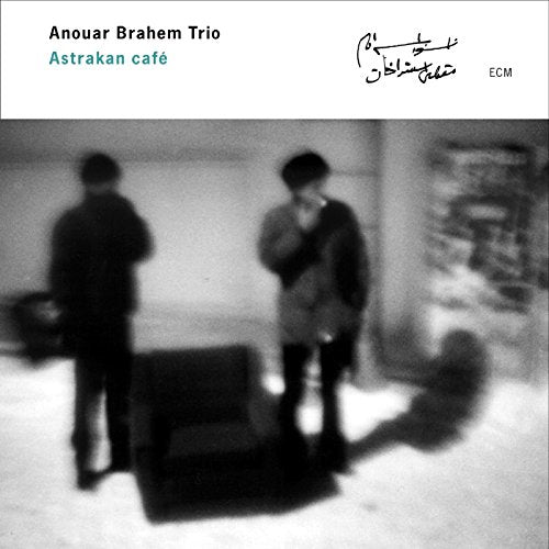 "Album cover with black and white photo of two men standing near a chair."