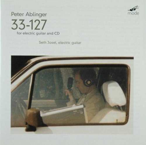 Album cover with a man recording in a car, white background.
