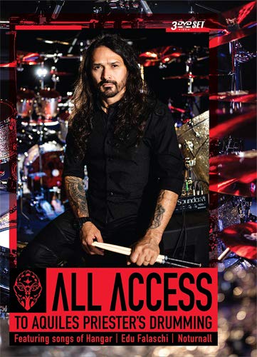 Man with long hair and tattoos sits behind a drum kit, holding drumsticks.