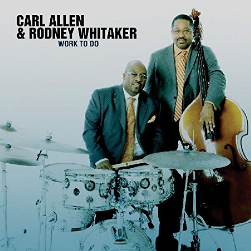"Album cover featuring two men in suits with a drum set and double bass."