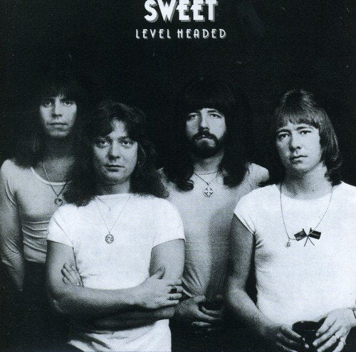 "Black and white album cover with four men standing together, looking serious."