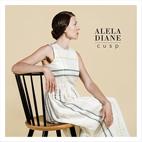 Album cover: woman in white dress sitting on a wooden chair, beige background.