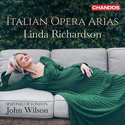 Woman in green dress reclines on couch, surrounded by foliage, on a CD cover.