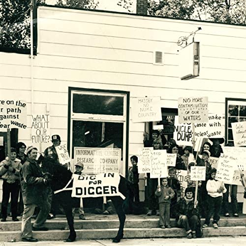 Black and white photo of protestors with signs in front of a building.