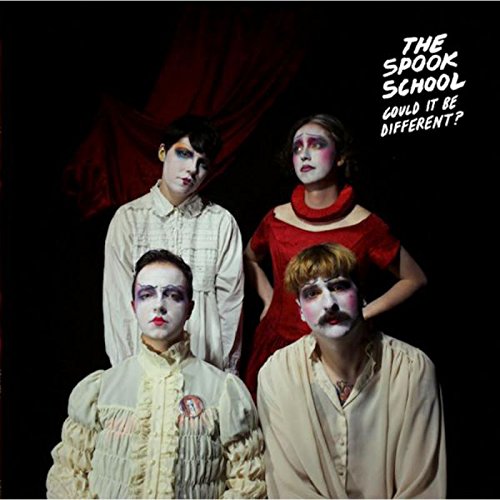 "Album cover featuring four people with pale makeup and dark eye shadow against a black background."