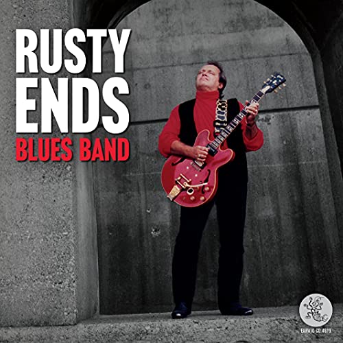 CD cover: musician with red guitar against a textured grey wall.