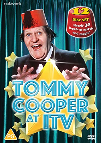 Tommy Cooper wearing a red fez hat in front of a green curtain background.