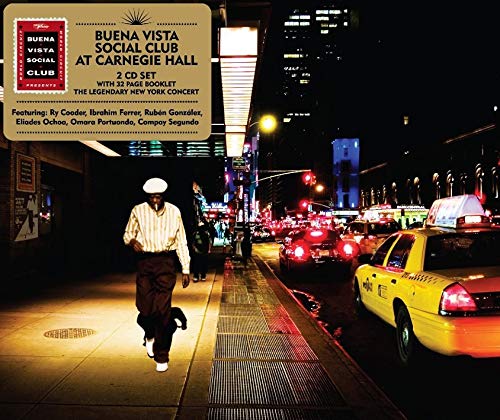 "CD cover with man walking on sidewalk, yellow taxi, and city street at night."