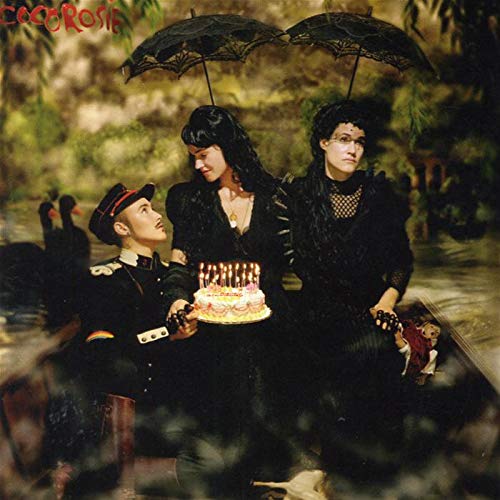 Cocorosie album cover: three figures with a birthday cake in a surreal landscape.