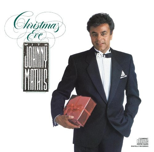 Johnny Mathis in a suit holding a gift, album cover art.
