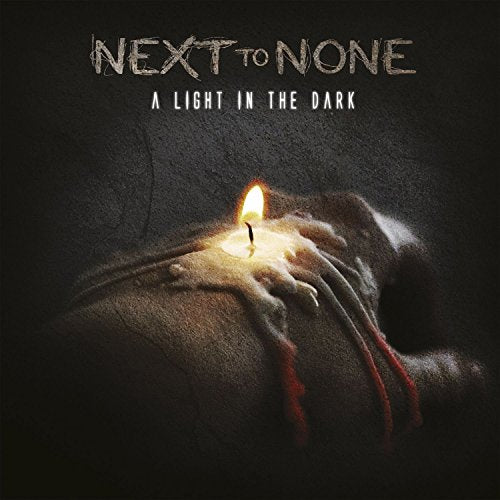 "Album cover with hands holding a lit candle, 'Next to None' text above."