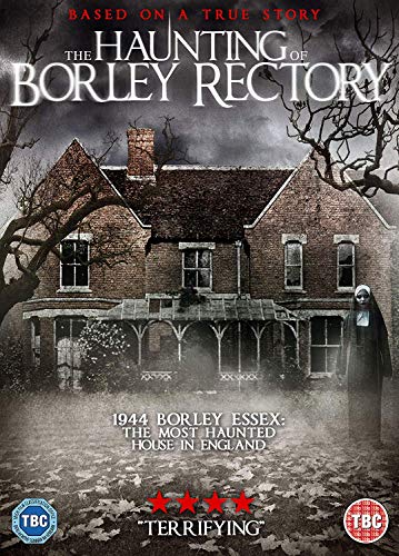 Large haunted house with a woman in a black dress standing to the right.