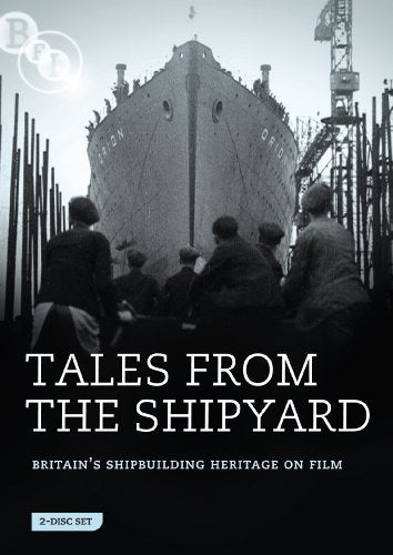 Black and white image of workers watching a large ship in a shipyard.