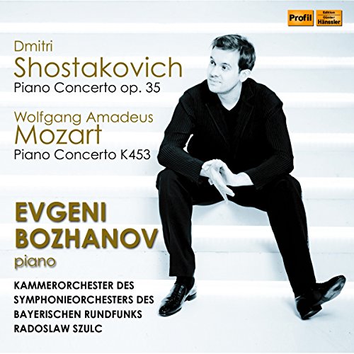 CD cover with a man sitting on white stairs, dressed in black, gold text.