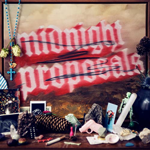 Vinyl album cover with red text, flowers, and assorted small objects.