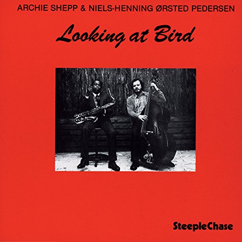 Red album cover with black text and a black-and-white photo of two musicians.