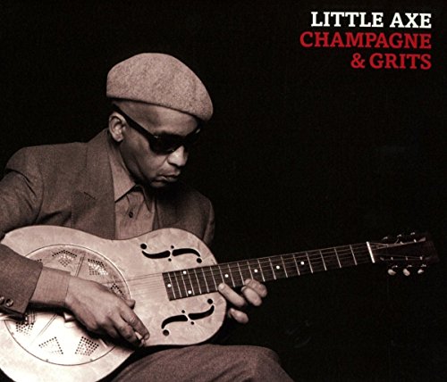 Little Axe plays a resonator guitar, wearing a cap and sunglasses.