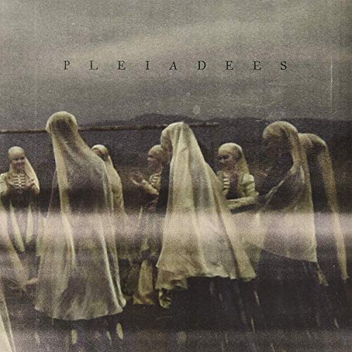 Group of figures in hooded cloaks against a hazy landscape.