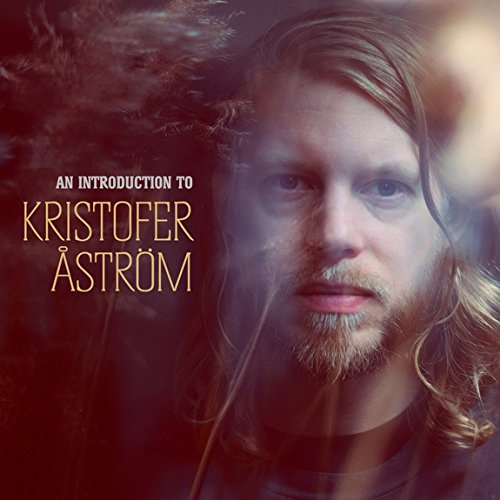 "CD cover featuring a man with long hair and a beard, dark background."