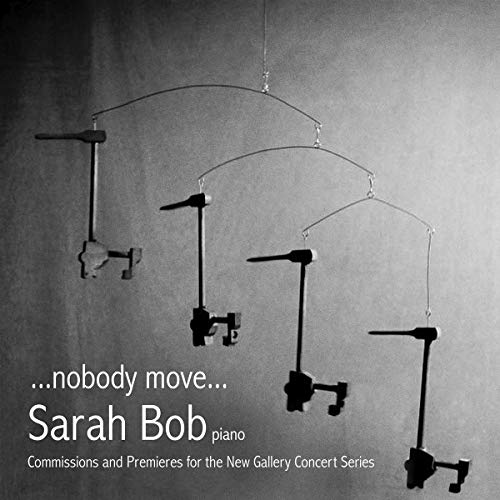 "Black-and-white image of a mobile with piano mechanisms, text describing a music album."