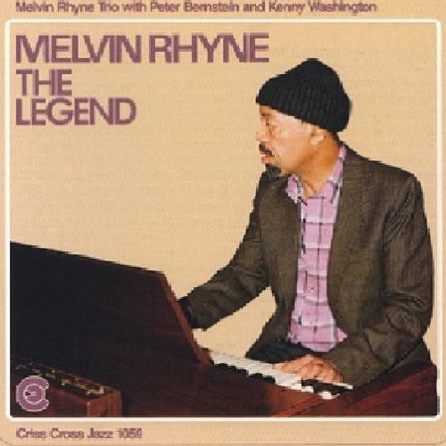 Album cover featuring a man playing piano, wearing a beanie and suit jacket.