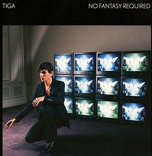 Man in suit kneels before a stack of glowing, winged figures on TVs.
