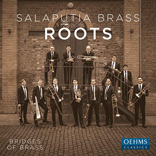 Brass band in suits stands on steps in front of brick building.