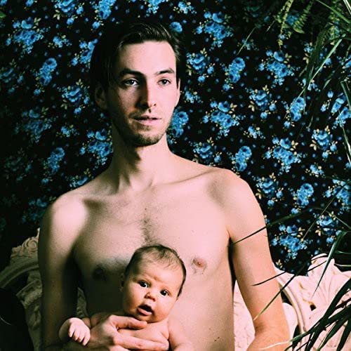 Man holding a baby, with a blue floral background.