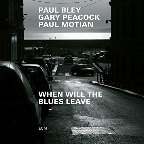 "Album cover with a black-and-white city street scene and white text."