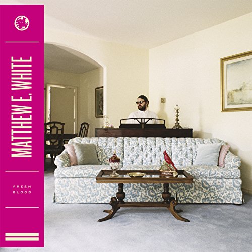 "Album cover with man standing behind sofa, pink vertical banner with artist's name."