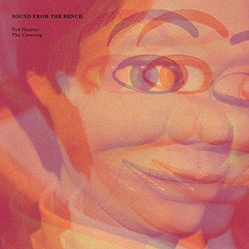 A close-up album cover featuring a person's face in orange and red tones.
