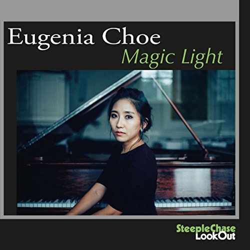 "Eugenia Choe sitting beside a grand piano, wearing a black top, on album cover."