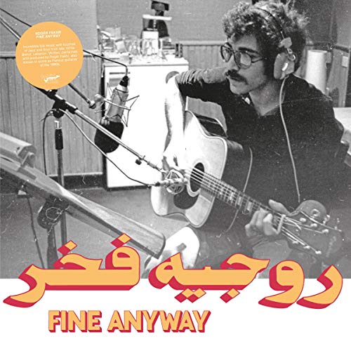 Black and white photo of Roger Fakhr playing acoustic guitar in a recording studio.