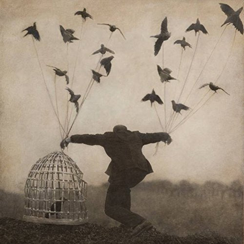 "Album cover with silhouette of a man releasing birds from a cage."