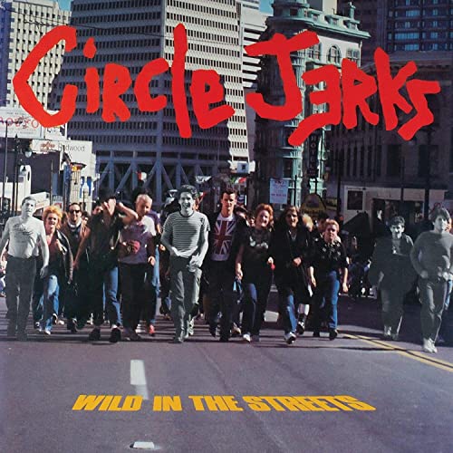 A group of people walking down a city street with red band logo above.