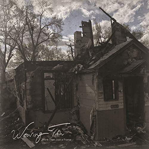 Black and white photo of a severely damaged, burned-out house.
