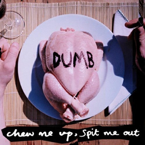 A raw turkey on a white plate with "DUMB" written on it.